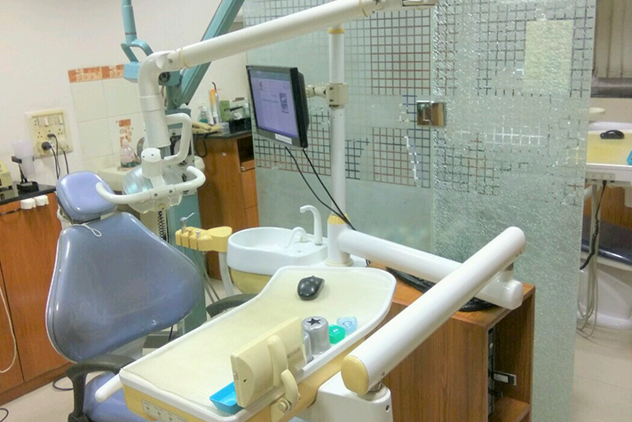Dental treatment chair beside a glass partition