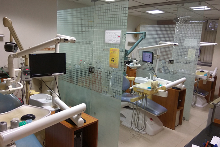 Dental chairs separated by frosted glass partitions